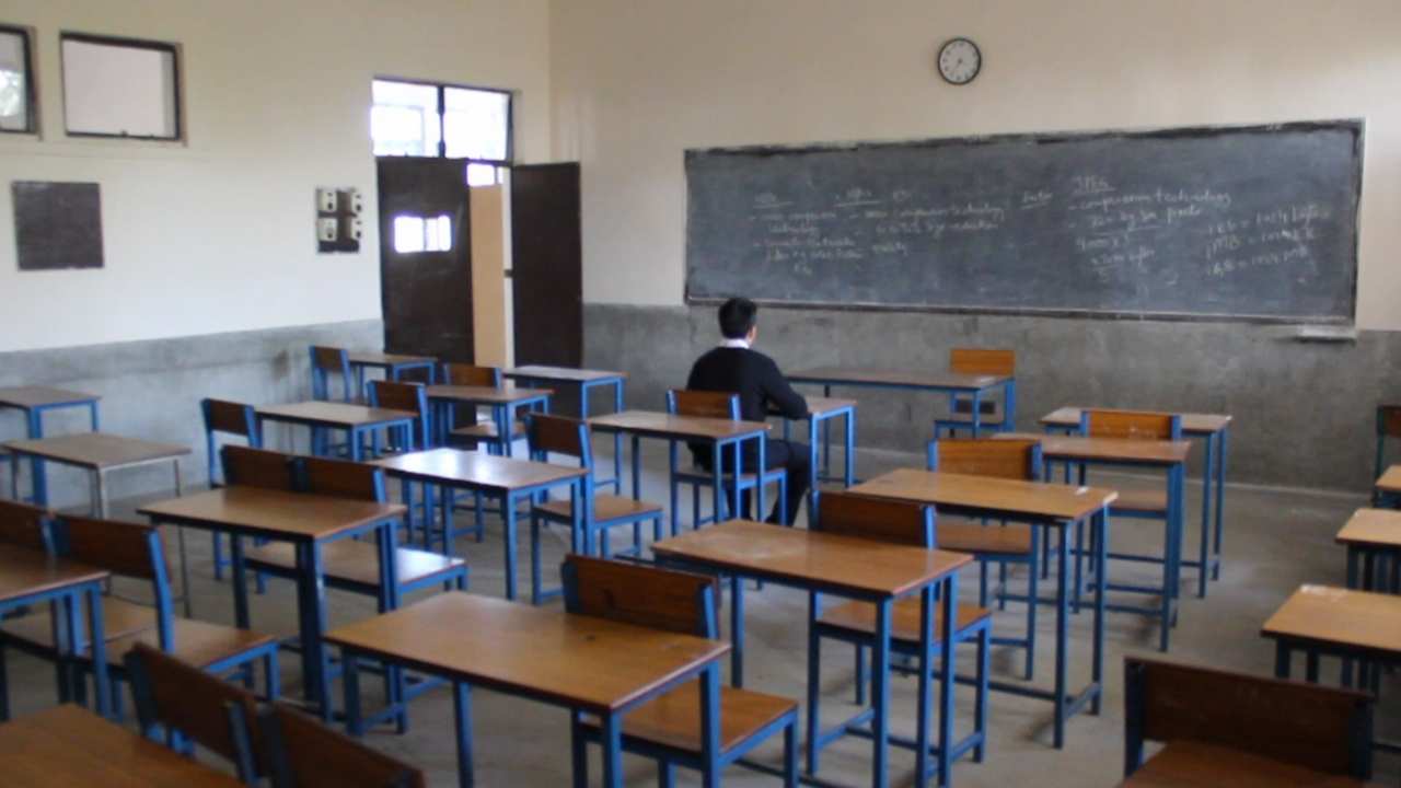 a person sitting in an empty classroom